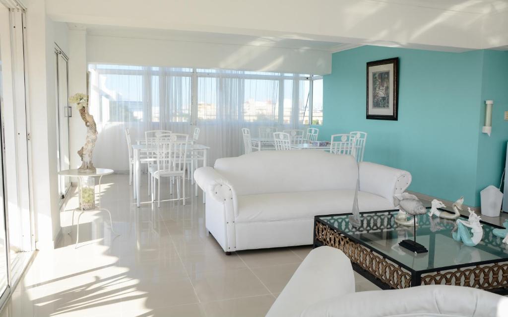 Salón con pared azul y sofá blanco